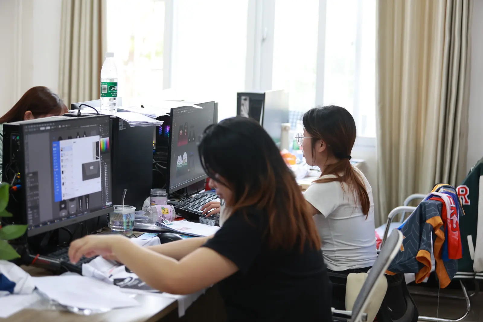 TONTON designers preparing custom sportswear artwork on computers